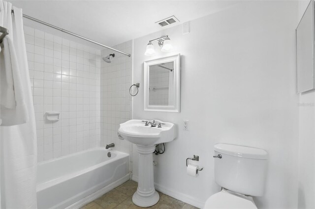 full bathroom featuring toilet, shower / tub combo, baseboards, and visible vents