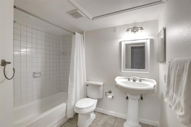 bathroom featuring toilet, visible vents, baseboards, tile patterned floors, and shower / bathtub combination with curtain