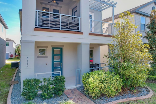 view of front of home featuring a balcony, central AC unit, and ceiling fan