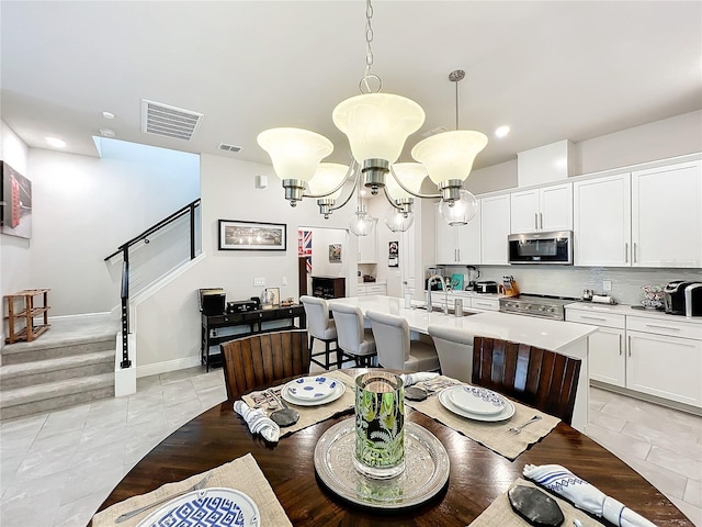 tiled dining space with sink and a notable chandelier