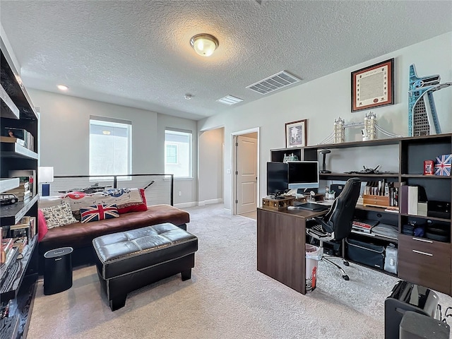 carpeted home office featuring a textured ceiling