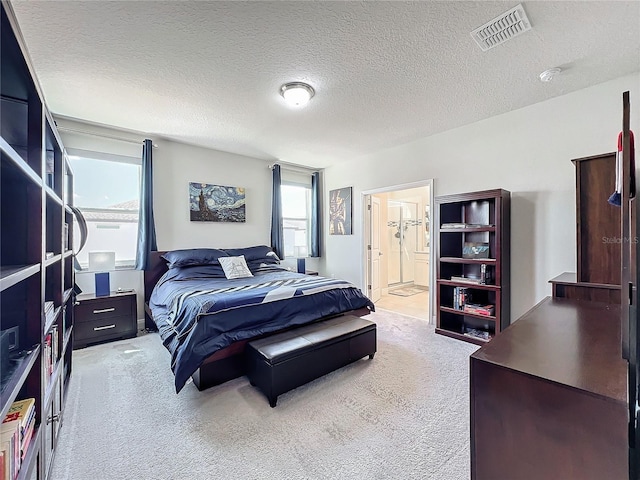 bedroom featuring carpet flooring, a textured ceiling, and ensuite bath