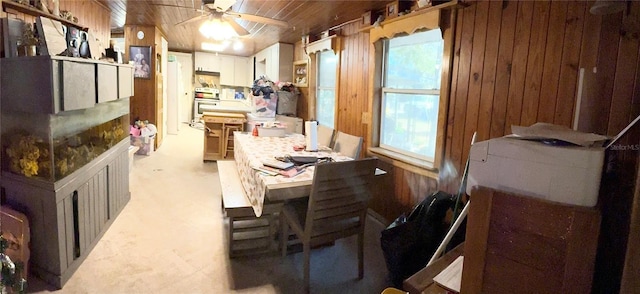 dining space featuring ceiling fan, wood ceiling, and wooden walls