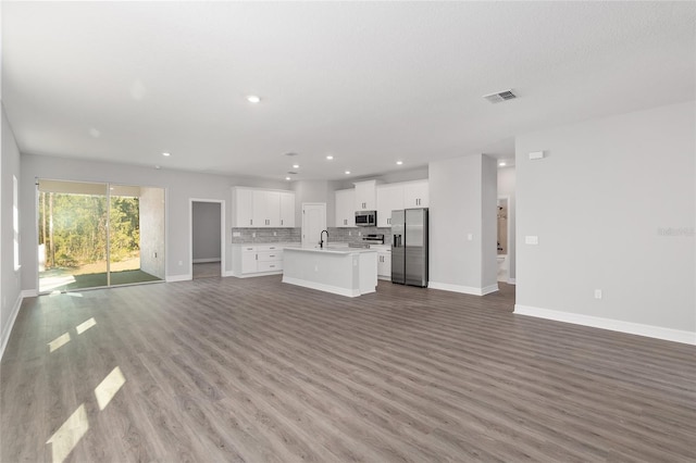 unfurnished living room featuring wood-type flooring and sink