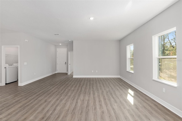 unfurnished room featuring light hardwood / wood-style flooring and washing machine and clothes dryer