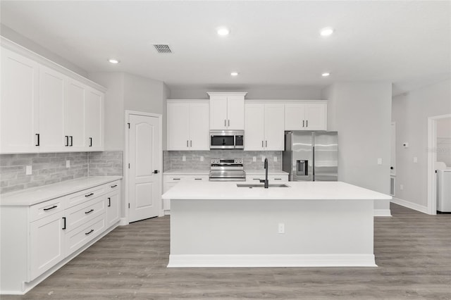 kitchen featuring a center island with sink, white cabinets, light hardwood / wood-style flooring, and appliances with stainless steel finishes