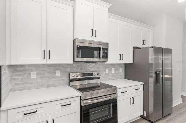 kitchen featuring stainless steel appliances, light wood-type flooring, backsplash, and white cabinetry