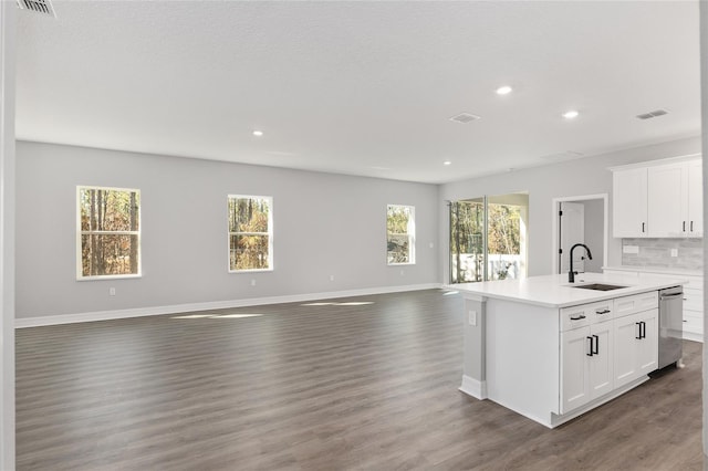 kitchen with sink, white cabinetry, stainless steel dishwasher, and a center island with sink