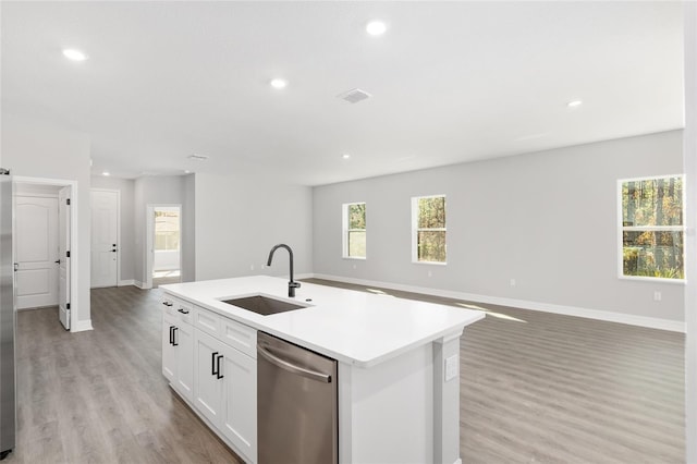 kitchen with dishwasher, light hardwood / wood-style floors, a kitchen island with sink, white cabinetry, and sink