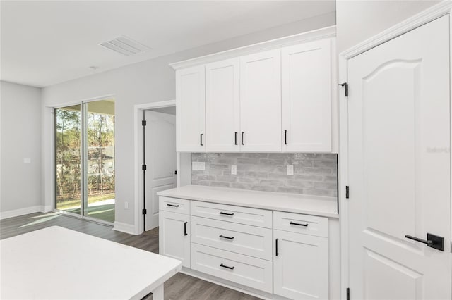 kitchen with white cabinetry, tasteful backsplash, and wood-type flooring