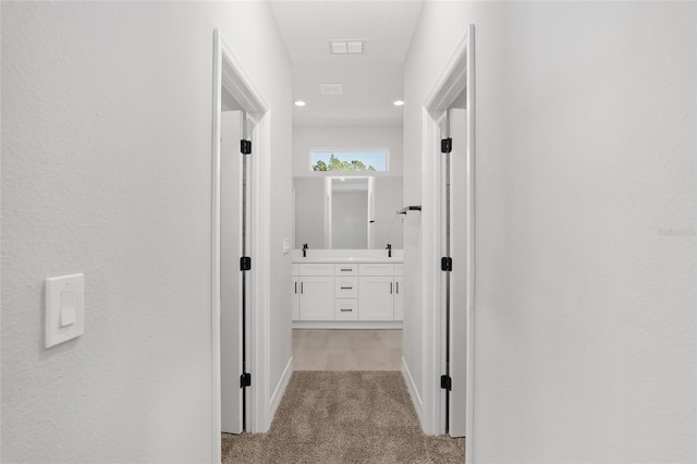 hallway with light colored carpet