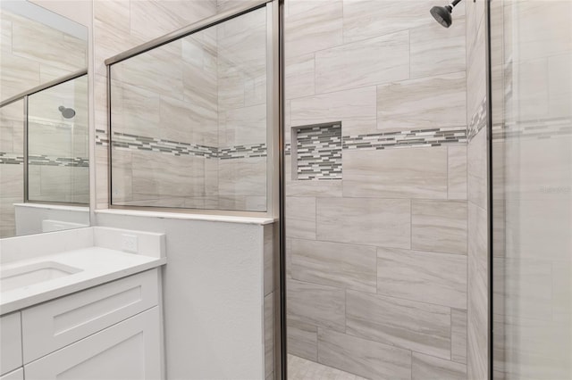 bathroom with a shower with door and vanity