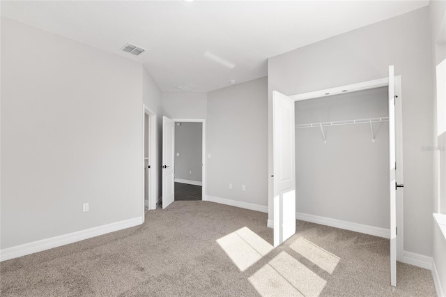 unfurnished bedroom featuring a closet and light carpet