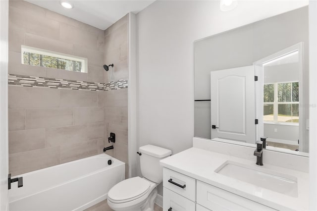 full bathroom featuring toilet, tiled shower / bath, and vanity