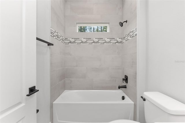 bathroom featuring toilet and tiled shower / bath