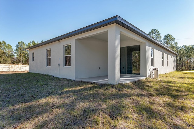 back of house with a patio and a yard