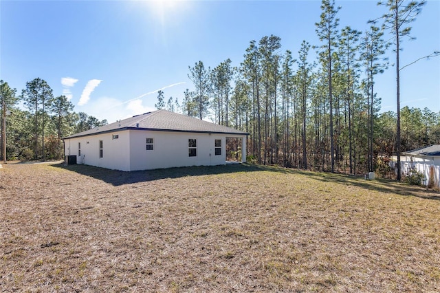 view of side of home with a yard and central AC unit