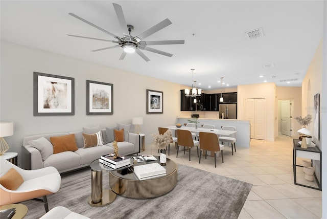 living room featuring light tile patterned flooring and ceiling fan with notable chandelier