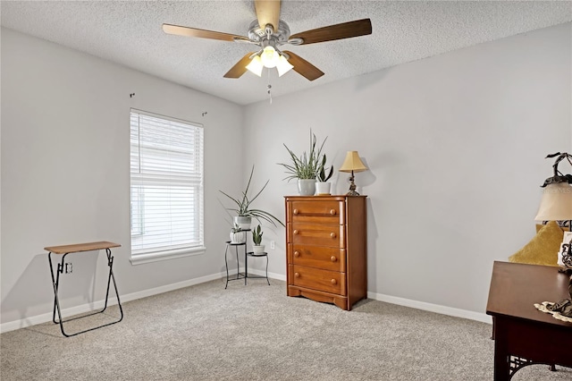 living area with ceiling fan, a wealth of natural light, light carpet, and a textured ceiling