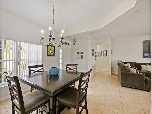 dining area featuring a healthy amount of sunlight, light tile patterned flooring, and a chandelier