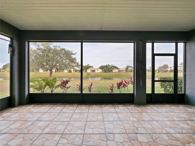 unfurnished sunroom with a wealth of natural light and a water view