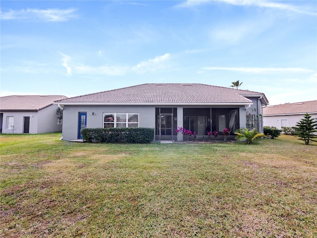 rear view of house with a yard and a sunroom