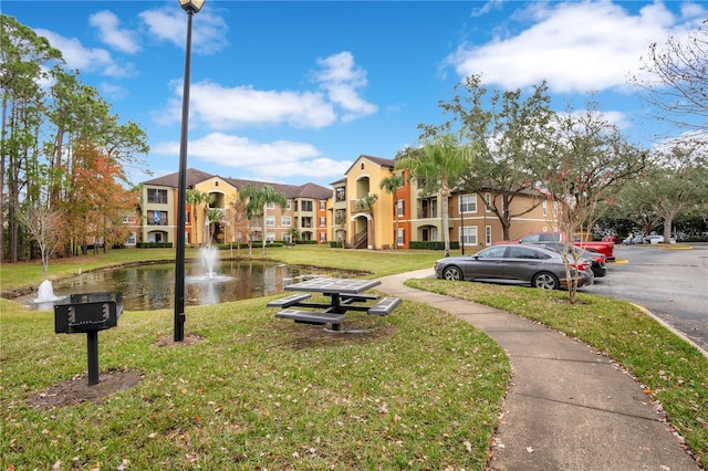 exterior space featuring a lawn and a water view