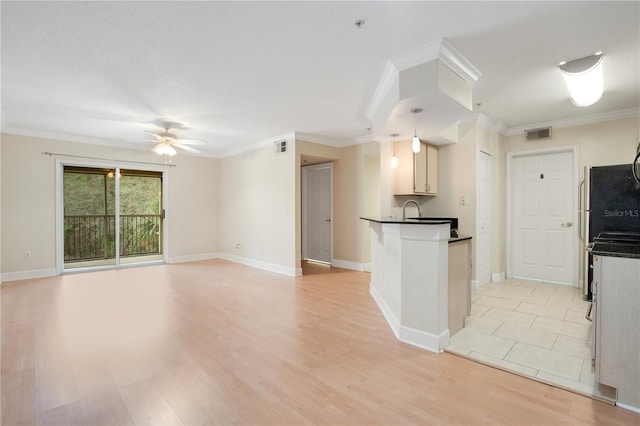 kitchen with decorative light fixtures, ceiling fan, crown molding, and light hardwood / wood-style floors