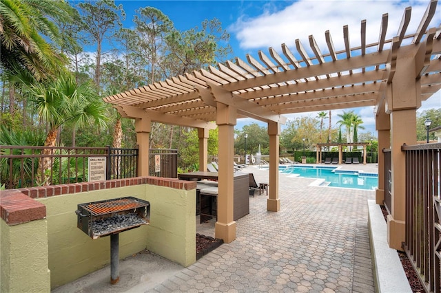 view of patio featuring a bar, a community pool, and a pergola