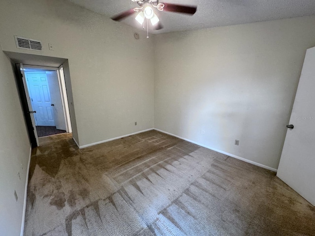 carpeted empty room featuring a textured ceiling and ceiling fan