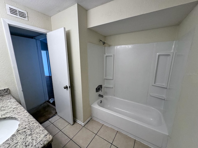 bathroom featuring vanity, shower / washtub combination, tile patterned flooring, and a textured ceiling