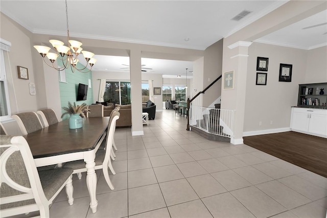 tiled dining room featuring ceiling fan with notable chandelier and ornamental molding