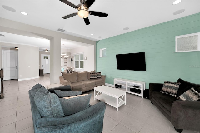 living room with ceiling fan with notable chandelier and light tile patterned floors