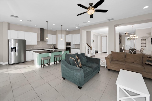 living room with light tile patterned floors, sink, and ceiling fan with notable chandelier