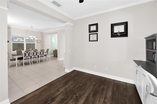 dining room with ornamental molding, light hardwood / wood-style floors, and a notable chandelier