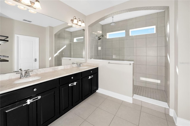 bathroom with vanity, tile patterned flooring, and tiled shower