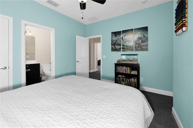 bedroom featuring ceiling fan, ensuite bath, and dark colored carpet