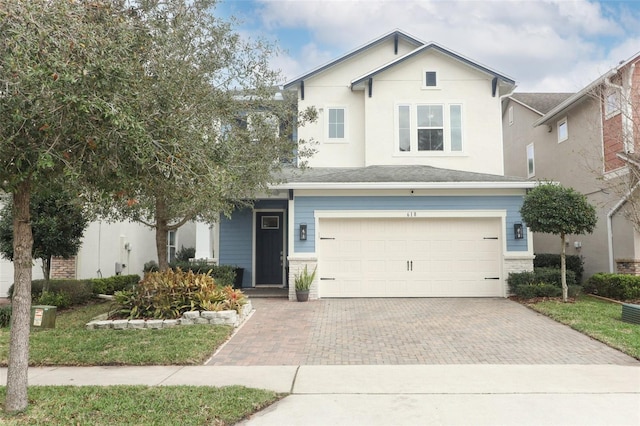 traditional-style house featuring a garage and decorative driveway