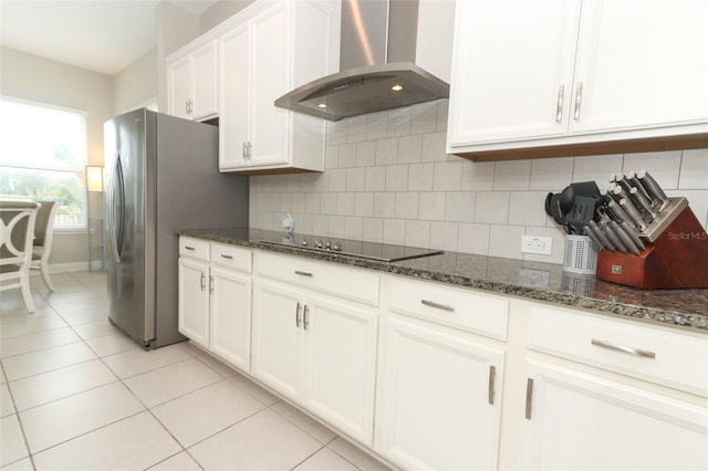 kitchen featuring black electric stovetop, extractor fan, white cabinetry, backsplash, and dark stone counters