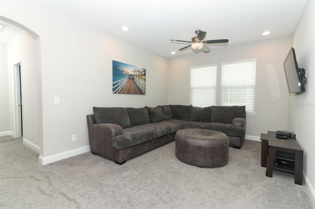 living room with recessed lighting, baseboards, arched walkways, and light colored carpet