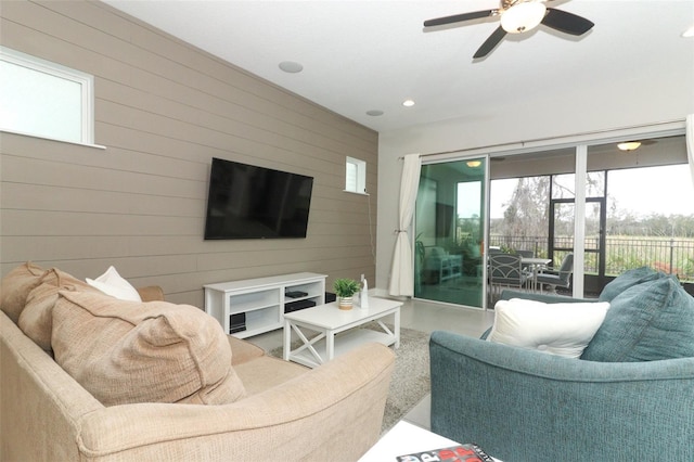 living area with wood walls, ceiling fan, and recessed lighting