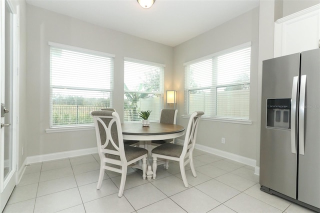 dining space with light tile patterned flooring and baseboards