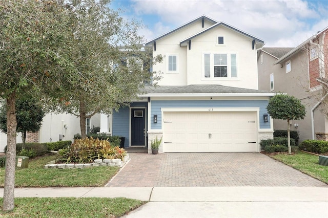 traditional-style house with decorative driveway, brick siding, and an attached garage