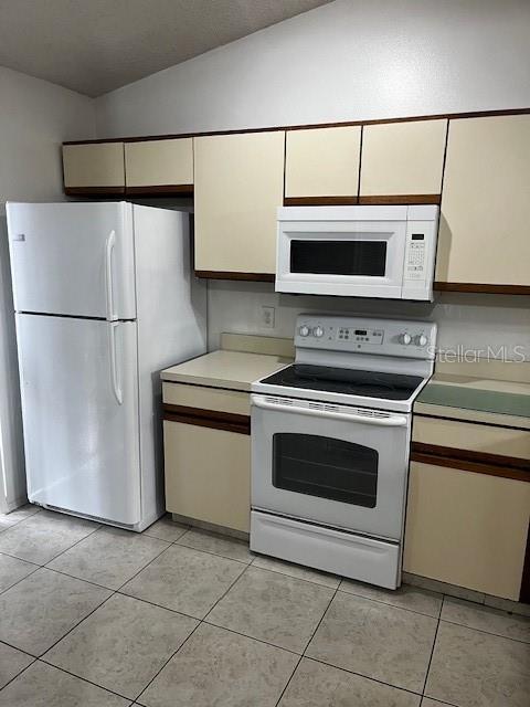 kitchen with white appliances and light tile patterned floors