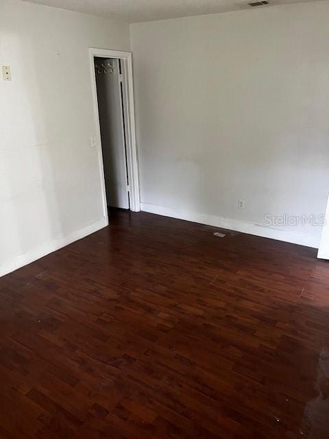 spare room with dark hardwood / wood-style flooring