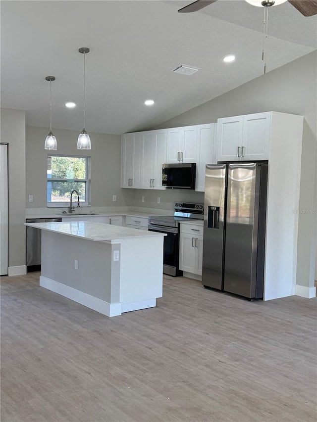 kitchen featuring sink, white cabinetry, stainless steel appliances, and hanging light fixtures