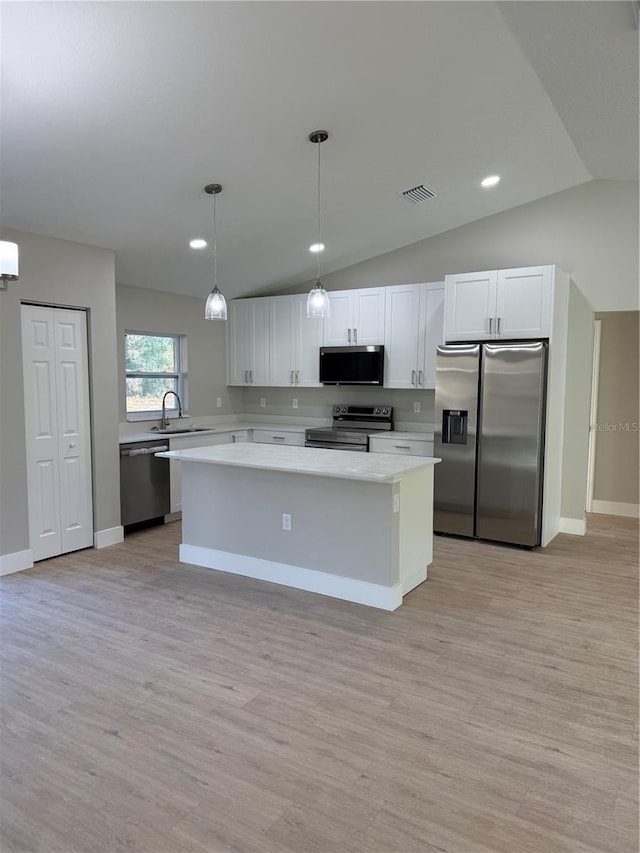 kitchen with white cabinetry, appliances with stainless steel finishes, sink, hanging light fixtures, and a center island