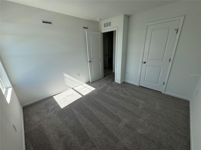 unfurnished bedroom with dark colored carpet