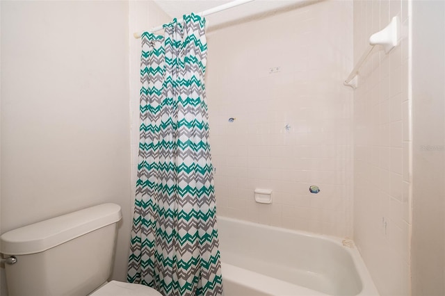 bathroom featuring toilet and tiled shower / bath