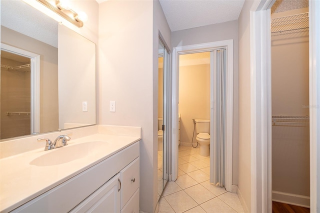 bathroom featuring tile patterned flooring, vanity, and toilet